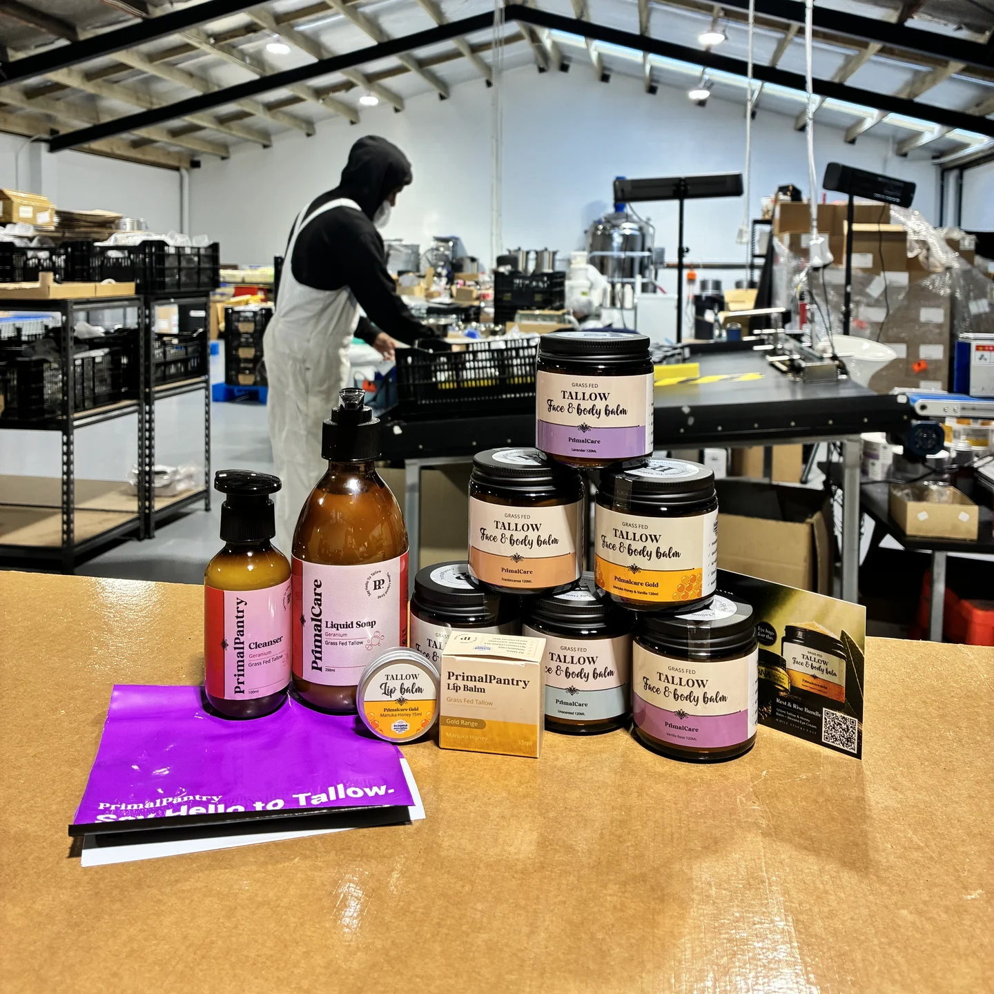 The 12 month routine laid out on the packing bench in our Christchurch workshop, six balm jars with the cleanser, liquid soap, lip balm and the welcome card
